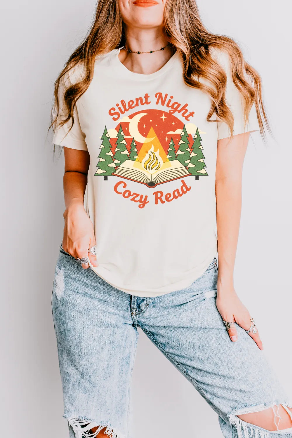 woman wearing cozy book lover t-shirt with campfire and open book design and "Silent night cosy read" quote
