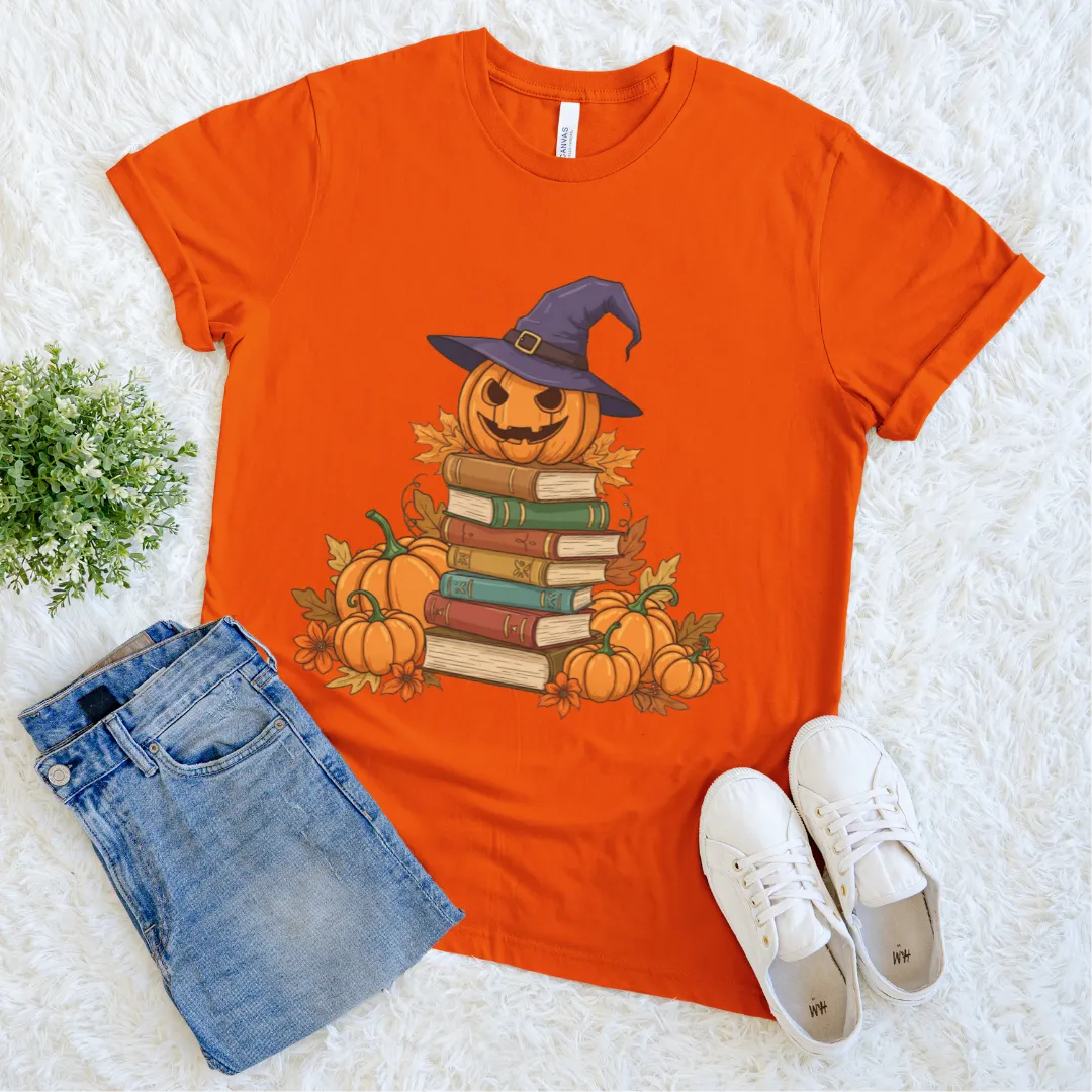 Orange halloween T-shirt with pumpkin witch sitting on stack of books and surrounded by pumpkins