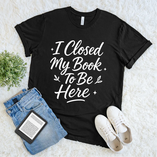 Black T-shirt with white text saying I Closed My Book To Be Here