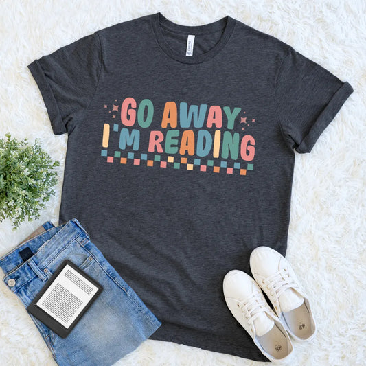 Dark gray t-shirt with 'Go Away I'm Reading' text, funny introvert reading tee