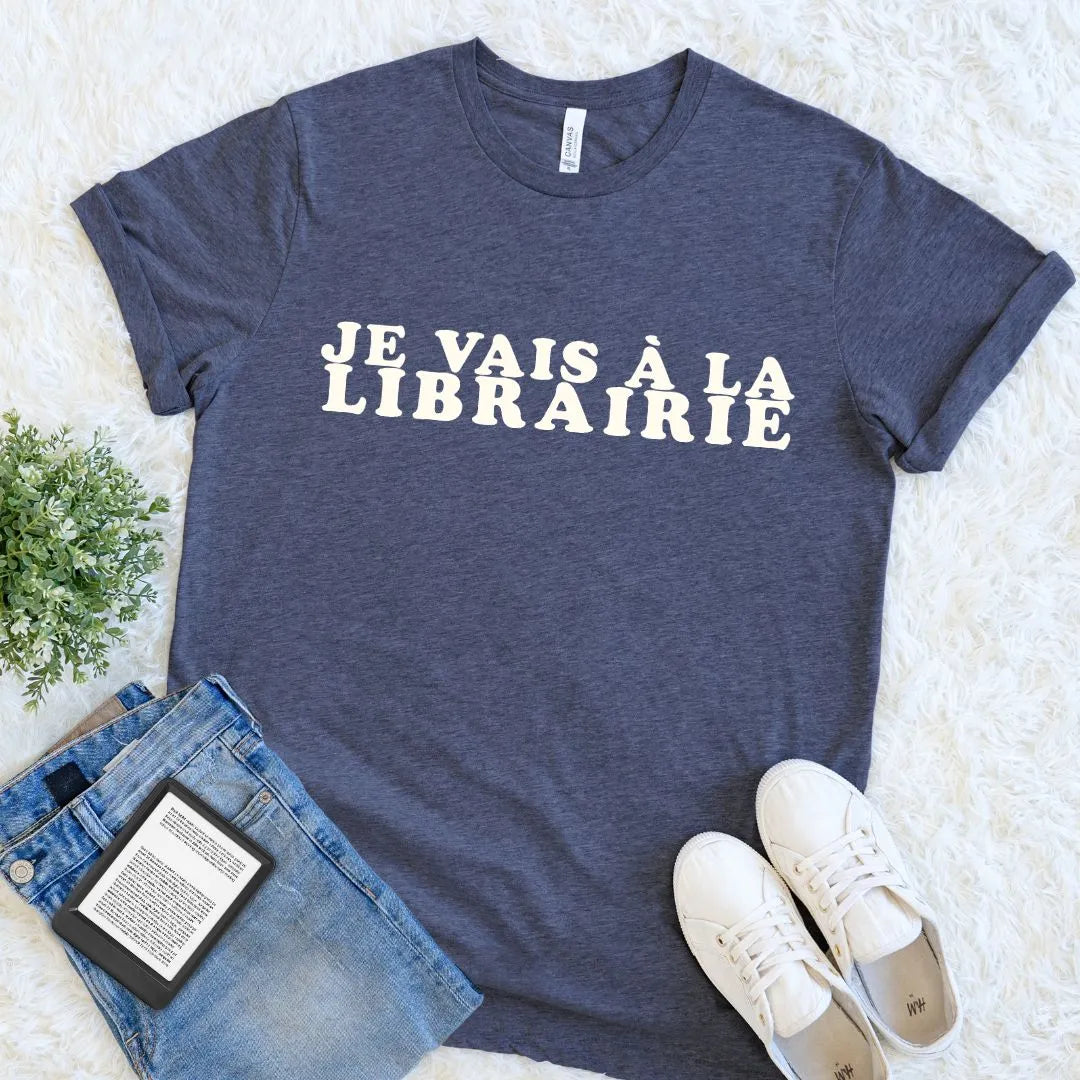 Heather navy bookstore graphic tee featuring the French phrase Je Vais à La Librairie in vintage cream type, arranged as an easy reader outfit