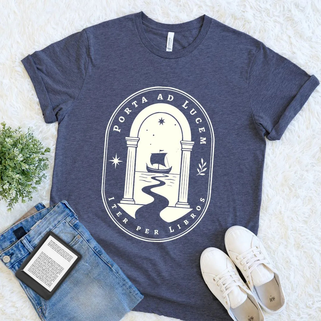 Heather Navy Porta ad Lucem book lover T-shirt with ivory archway, ship, stars, and Latin-inspired typography, a dark academia literary reader shirt styled flat.