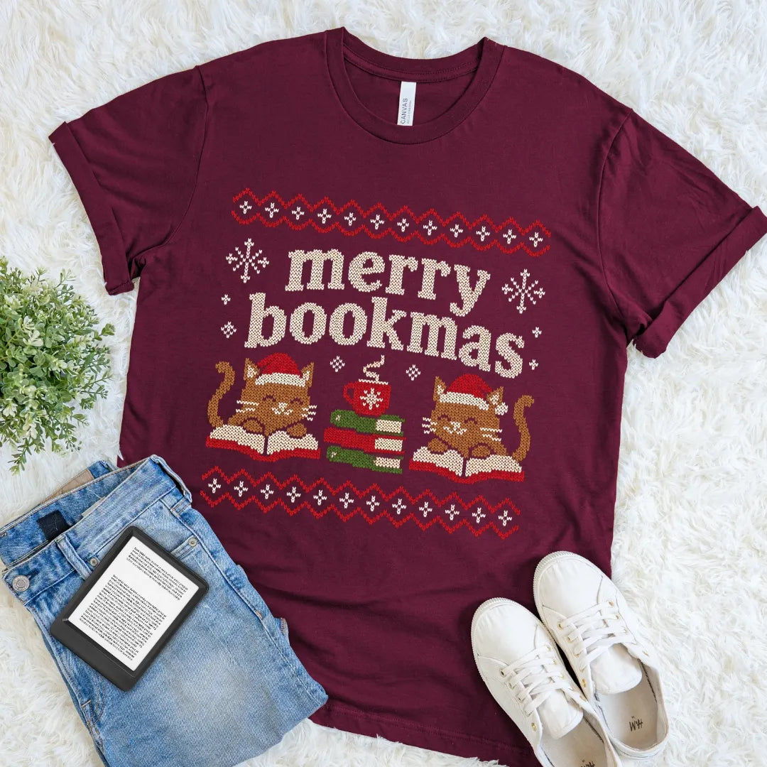Maroon Christmas cat shirt featuring books, cocoa, snowflakes, and festive knit-style details