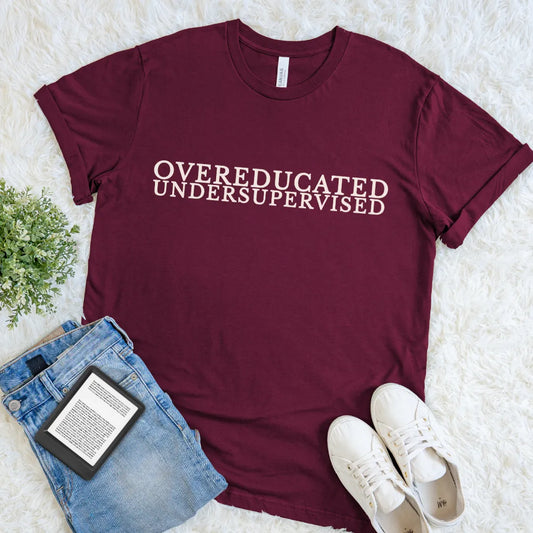 Maroon Overeducated & Undersupervised T-shirt with elegant cream serif typography and witty academia humor
