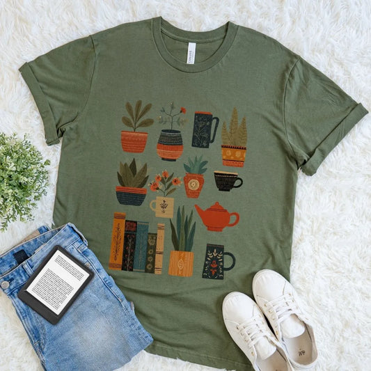 Flat lay of cozy reader shirt with potted plants and vintage books in earthy tones