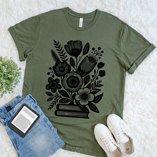 Green cozy literary shirt with black blooming flowers and book stack line art design