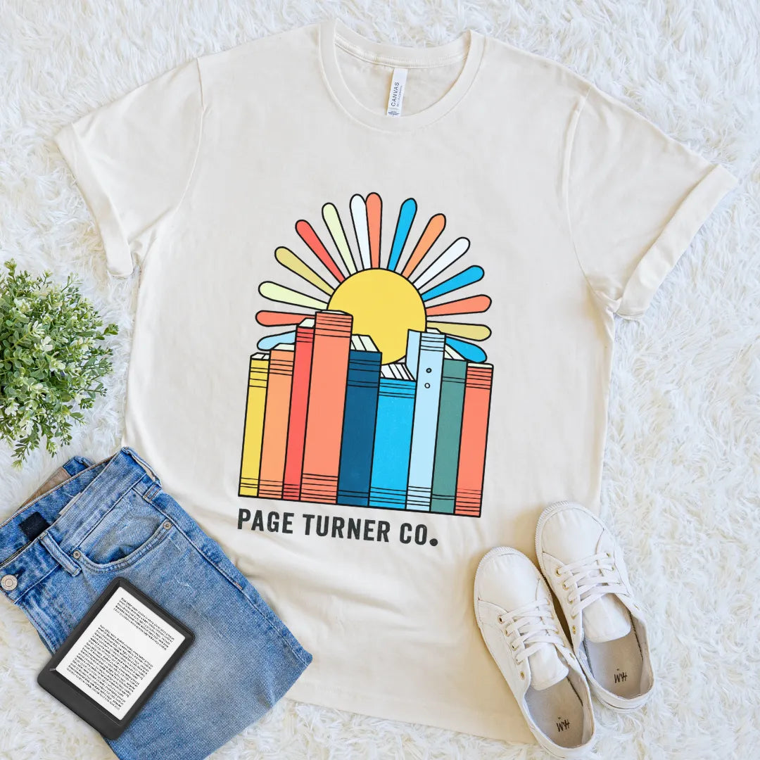 Cream T-shirt with colorful book stack and retro sunrise design