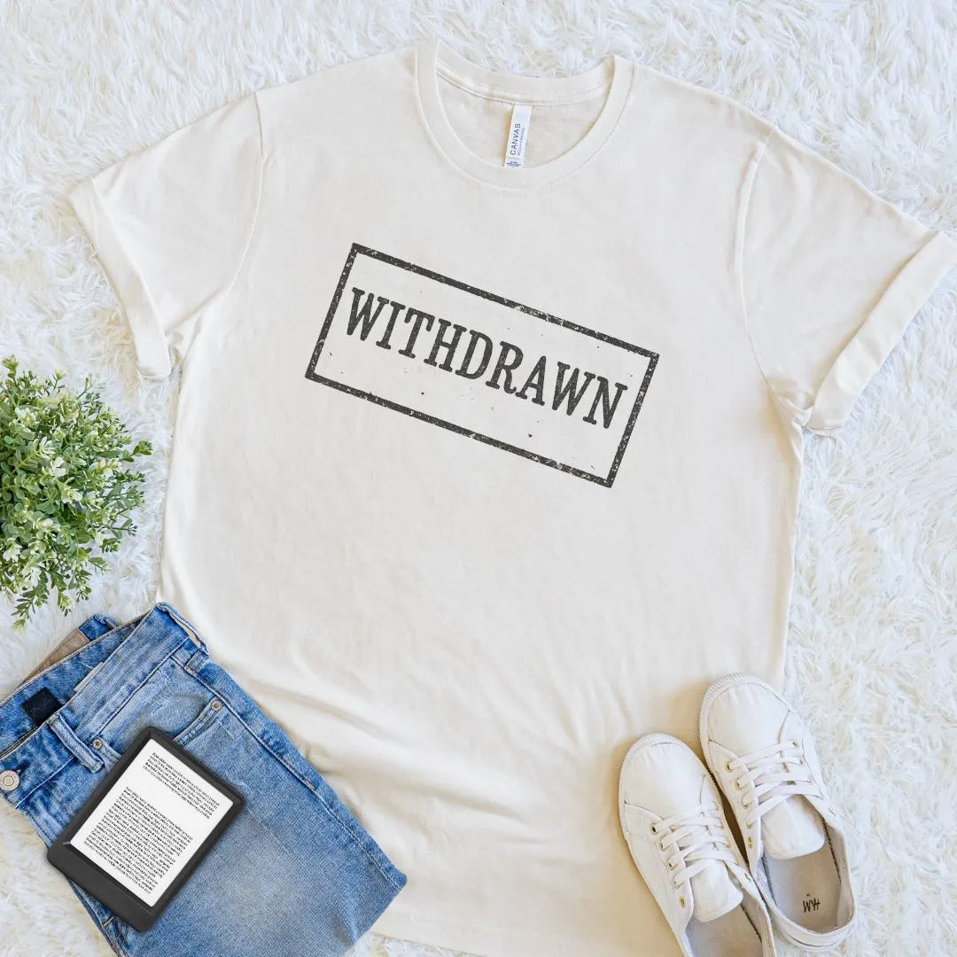 Soft cotton cream book lover tee with "withdrawn" old library stamp and cozy aesthetic