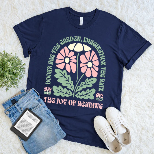 Navy blue t-shirt with boho floral design, placed on a light surface with jeans and sneakers and bookish quote
