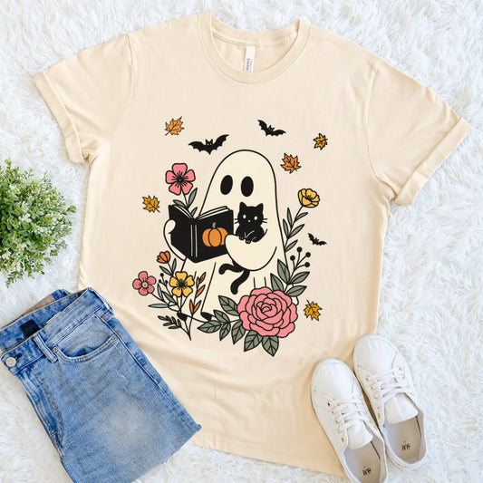 Cream tee featuring bookish halloween design with ghost and black cat surrounded by flowers and bats