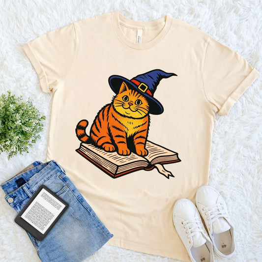 Halloween bookish tee with magical cat graphic and vintage storybook aesthetic on soft cream cotton