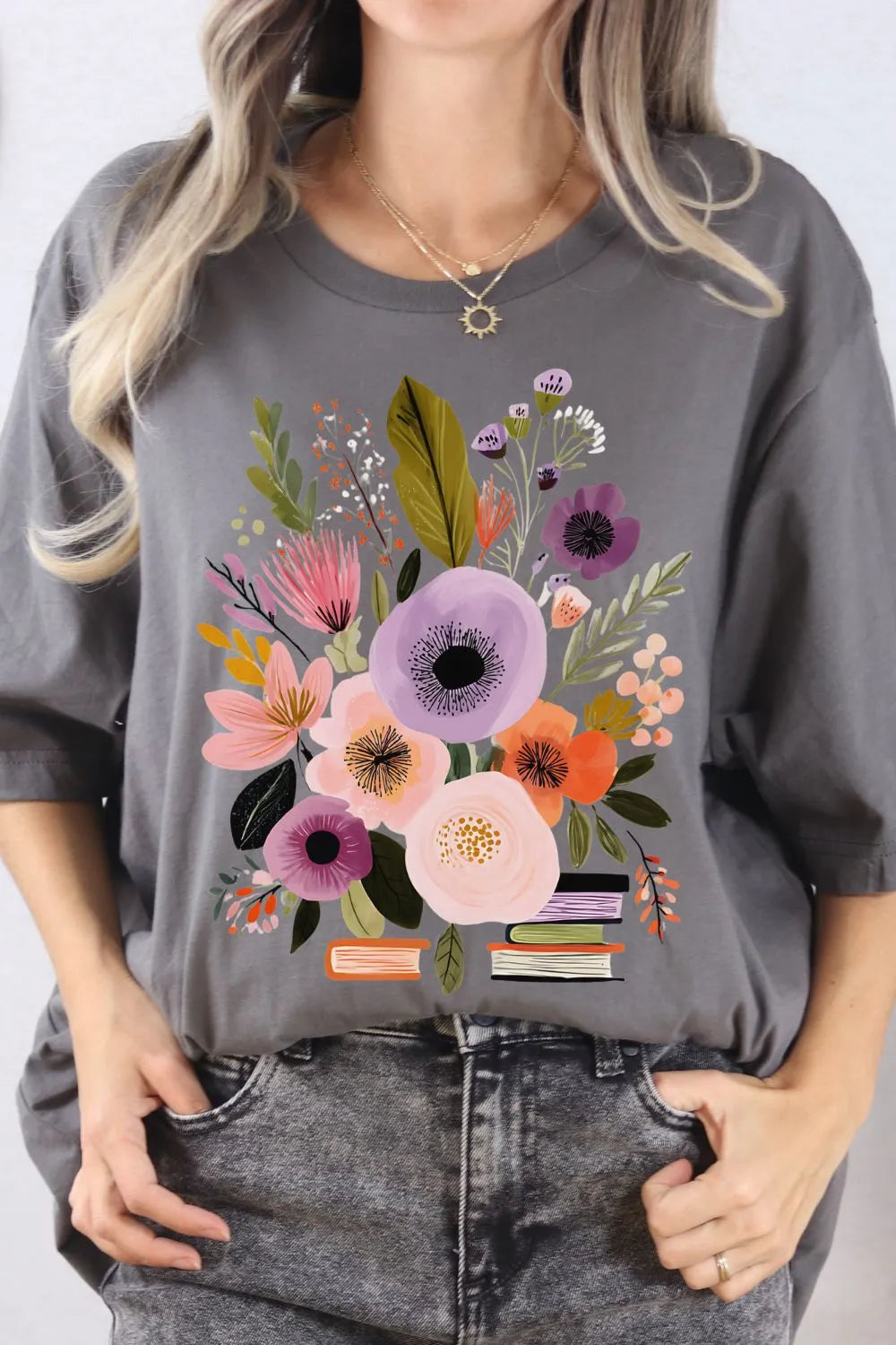 woman wearing soft cotton asphalt grey t-shirt with colourful wildflowers and books design