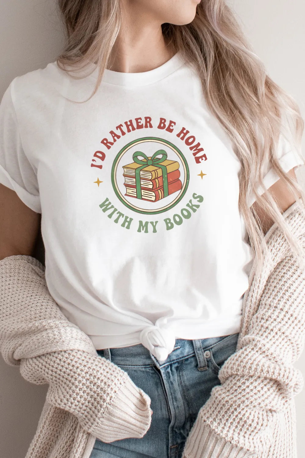 woman wearing gift-worthy T-shirt for quiet festive readers with stack of books and ribbon