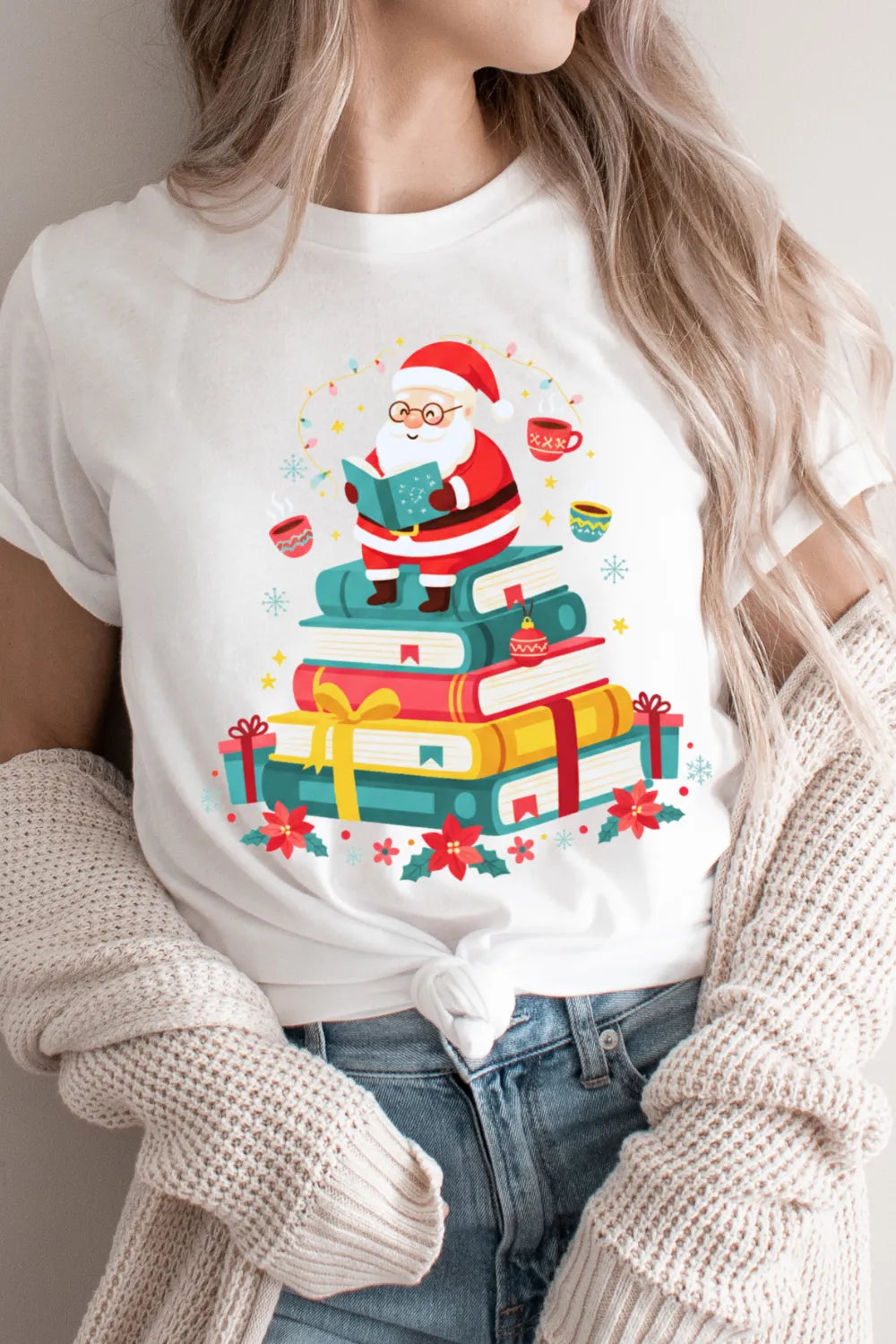 woman wearing wtite christmas tee featuring reading Santa and wrapped books