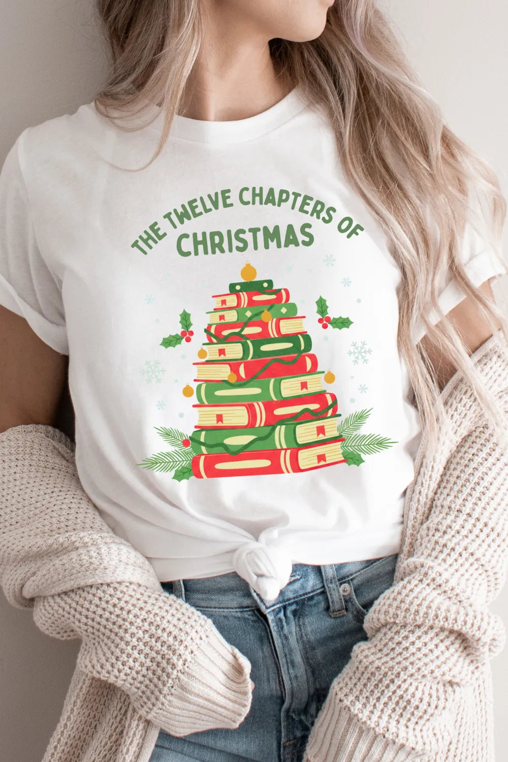 Woman wearing white vintage t shirt with whimsical festive design featuring books and holly