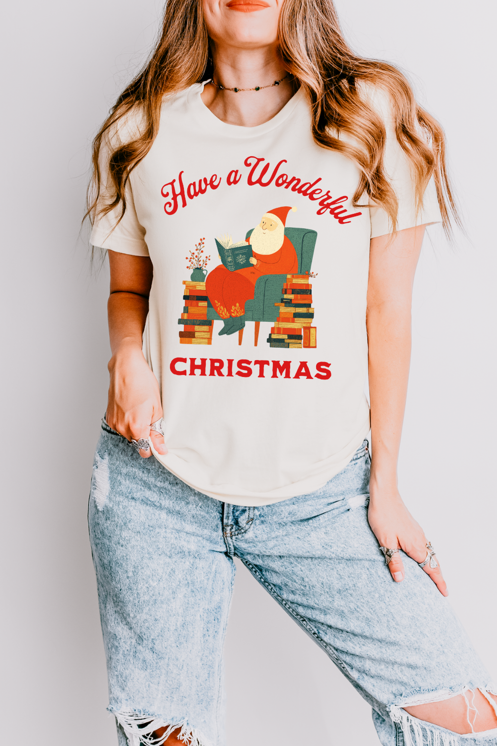 woman wearing vintage soft cotton reader t shirt with whimsical Santa scene  and “Have a Wonderful Christmas” text