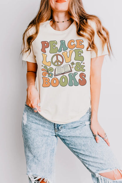 woman wearing cream groovy book shirt  with “Peace Love & Books” design and floral accents