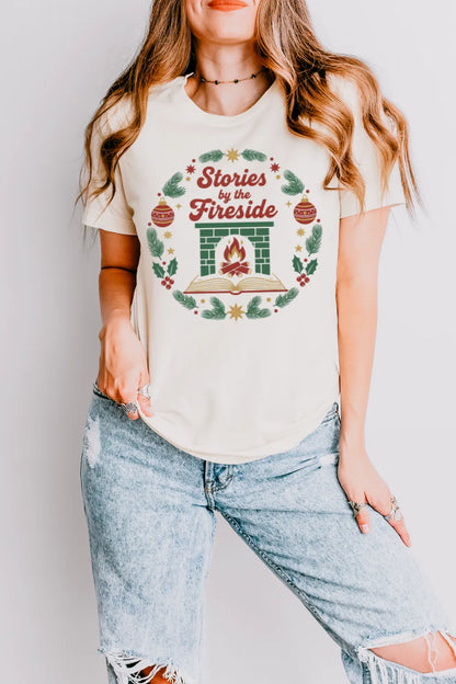 woman wearing  Cozy holiday bookish t-shirt with pine and ornament accents and “Stories by the Fireside” text
