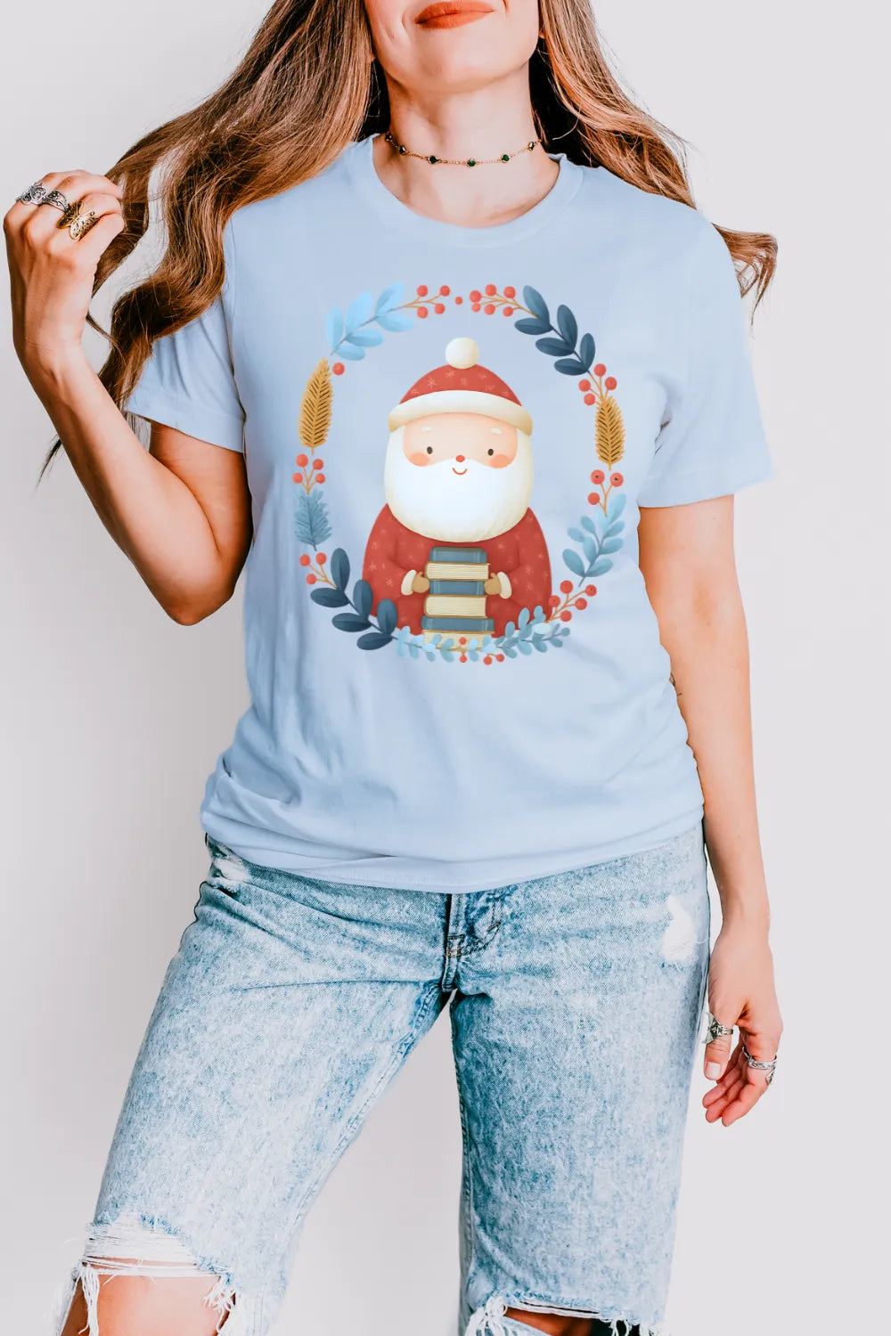 woman wearing literary festive t-shirt outfit featuring Santa holding books with gentle holiday aesthetic in light blue 