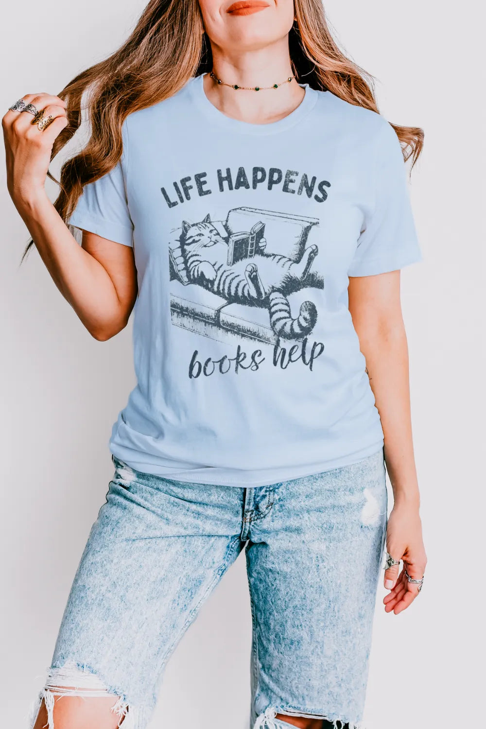 wonam wearing Introvert-friendly T-shirt for book and cat lovers with “Life Happens Books Help” quote