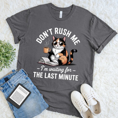 flat lay of dark grey t-shirt with procrastination cat book lover design 