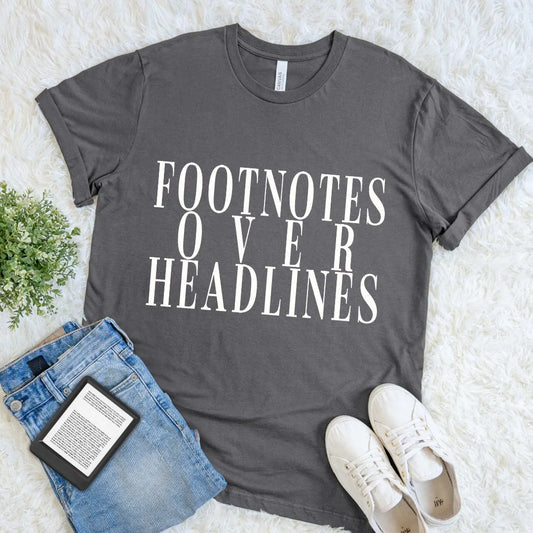 Charcoal gray book lover T shirt featuring the quote Footnotes Over Headlines in bold typography