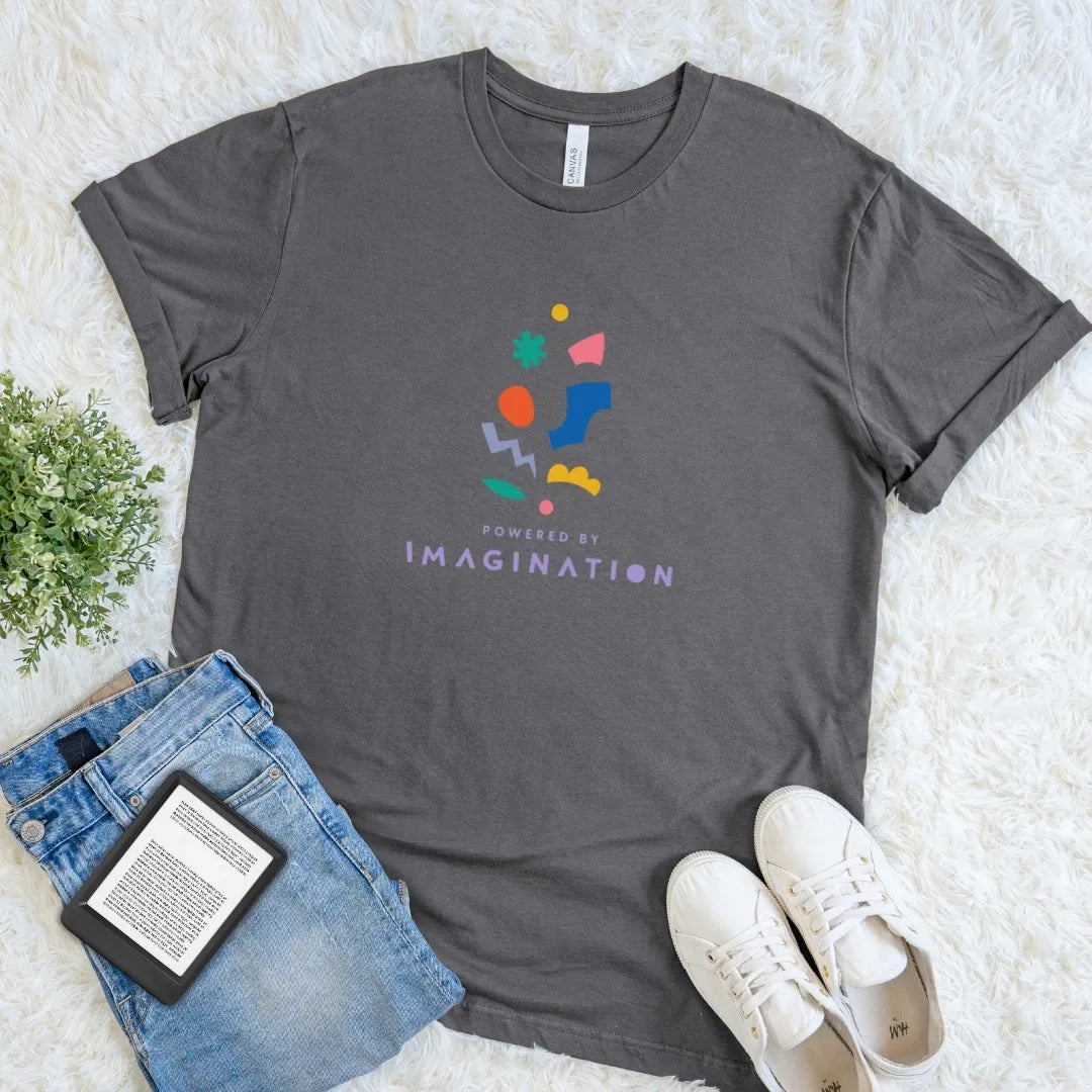 Asphalt Powered by Imagination reader shirt with colorful geometric accents and modern typography, an understated literary T-shirt with a creative book lover aesthetic.