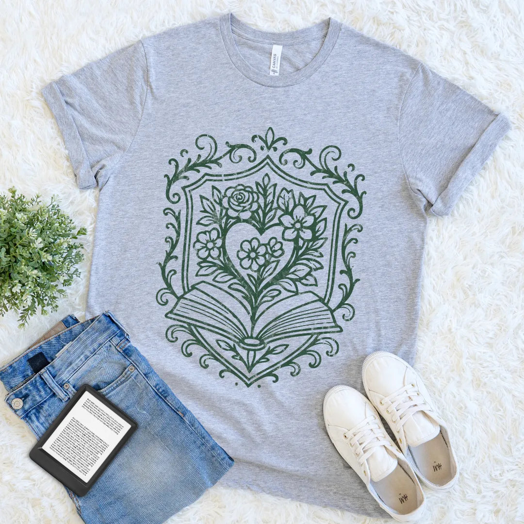 Minimalist athletic heather bookish tee with botanical heart and book line art design, paired with jeans and sneakers on a light background