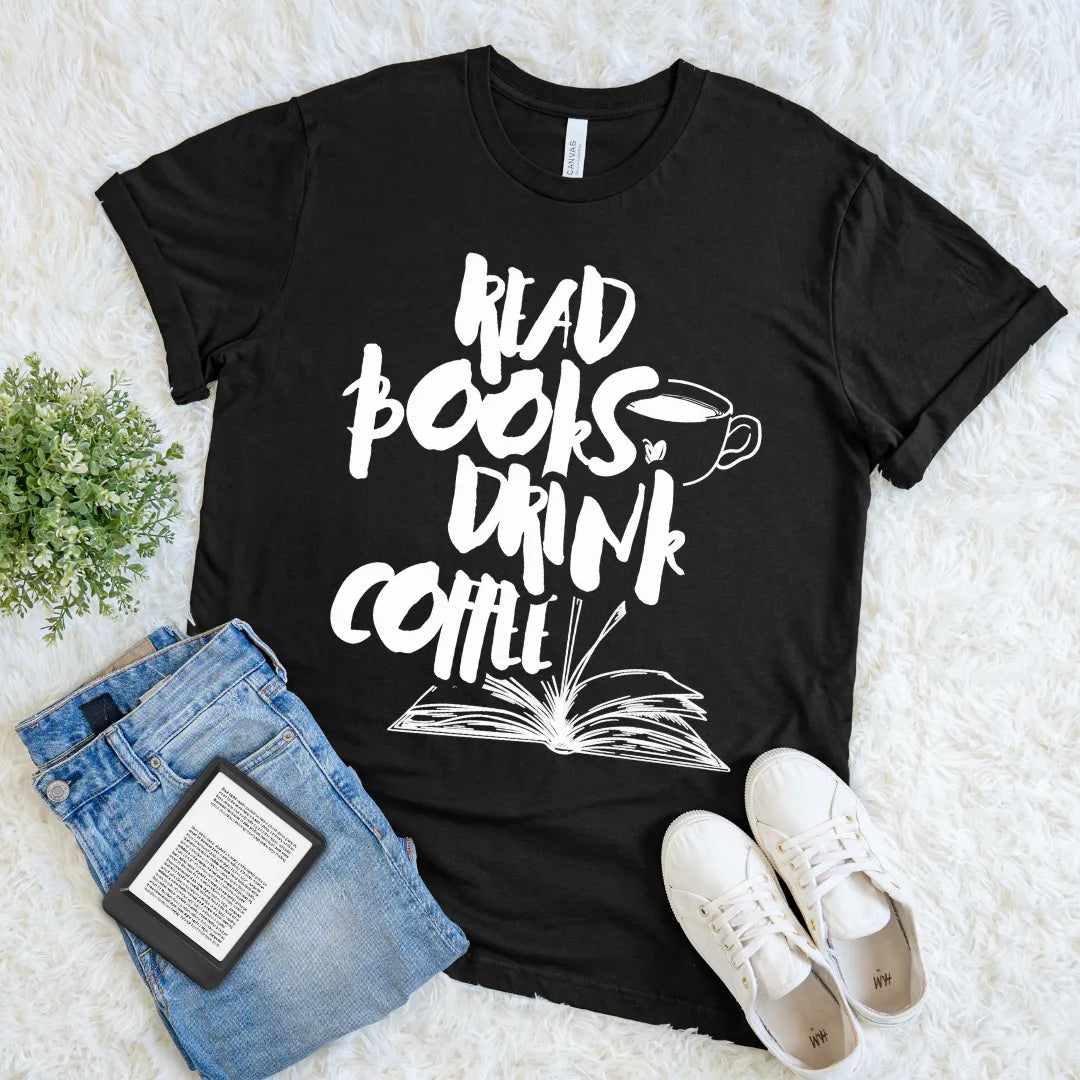 Black t-shirt with 'Read books, drink coffee' text on a white surface with jeans and shoes.