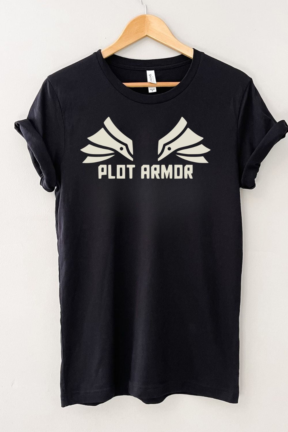 Black literary graphic t-shirt with “Plot Armor” text and minimalist wing design, styled as a casual bookworm aesthetic shirt