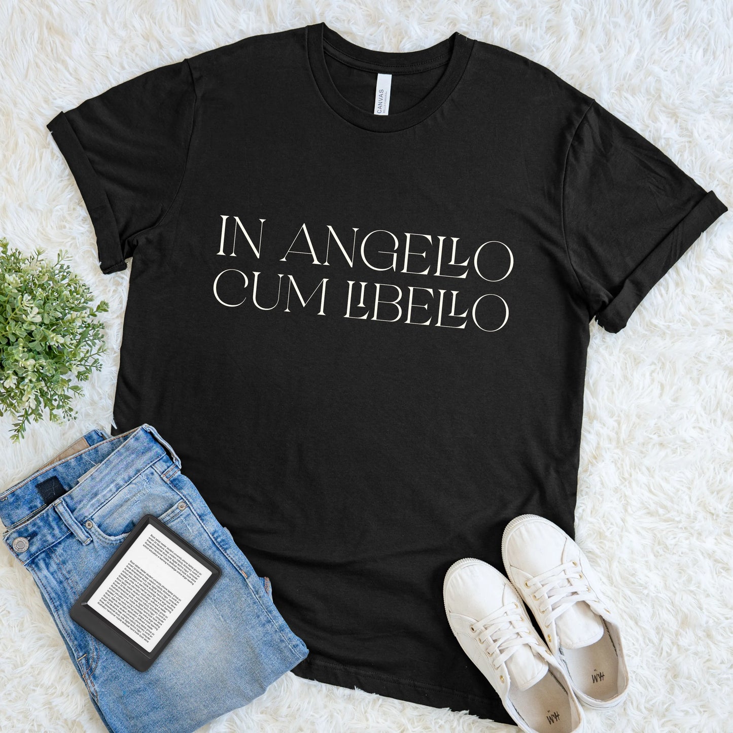 Black soft cotton aesthetic reader tee featuring latin quote styled with jeans, sneakers, and an e-reader