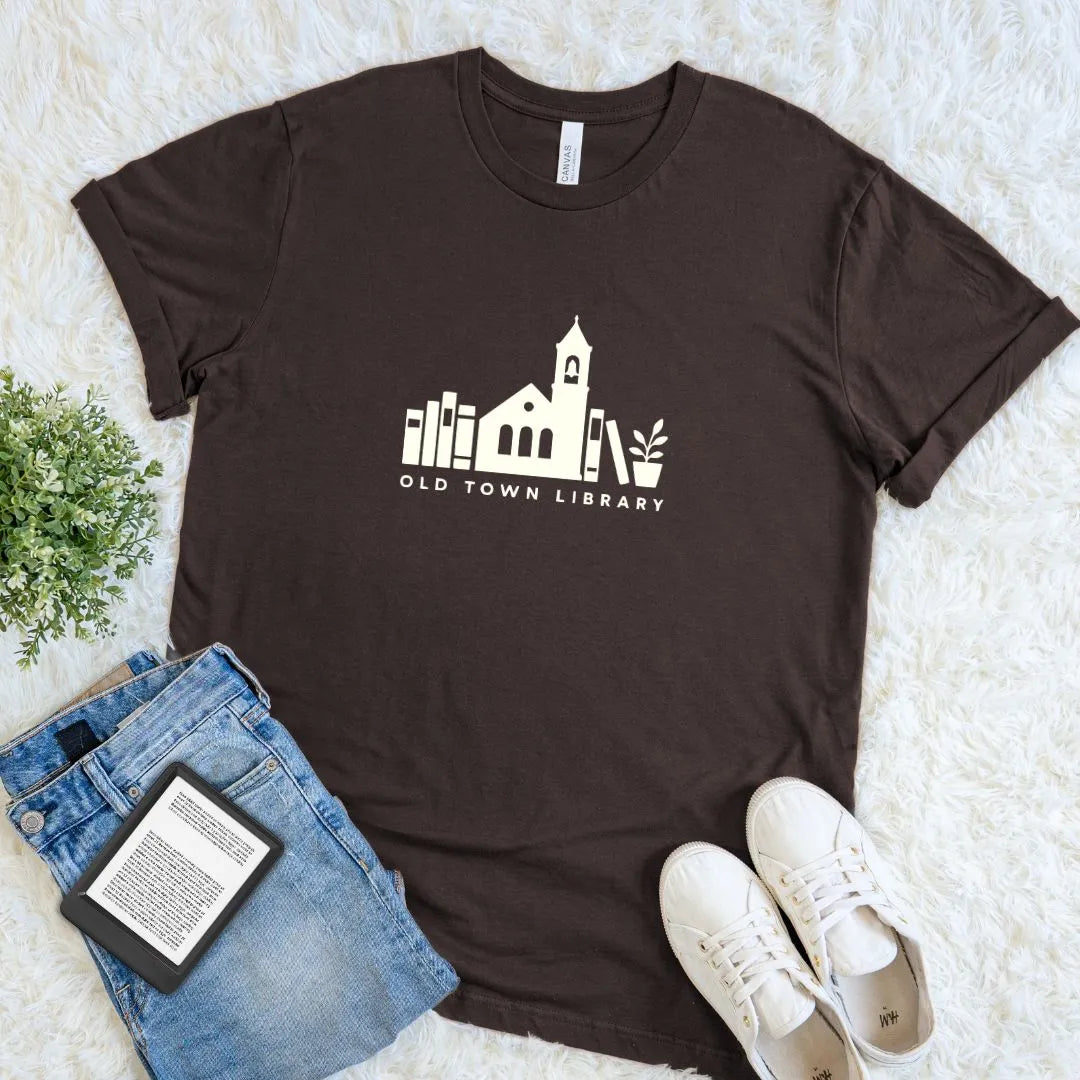 Minimalist bookish T-shirt featuring a charming library and books illustration on chocolate brown cotton