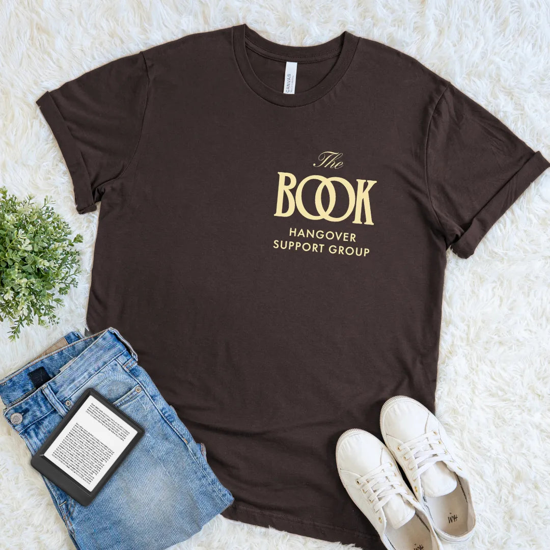Sot cotton brown Book lover tee for readers who get emotionally wrecked by fiction featuring golden logo  “the Book Hangover Support Group”