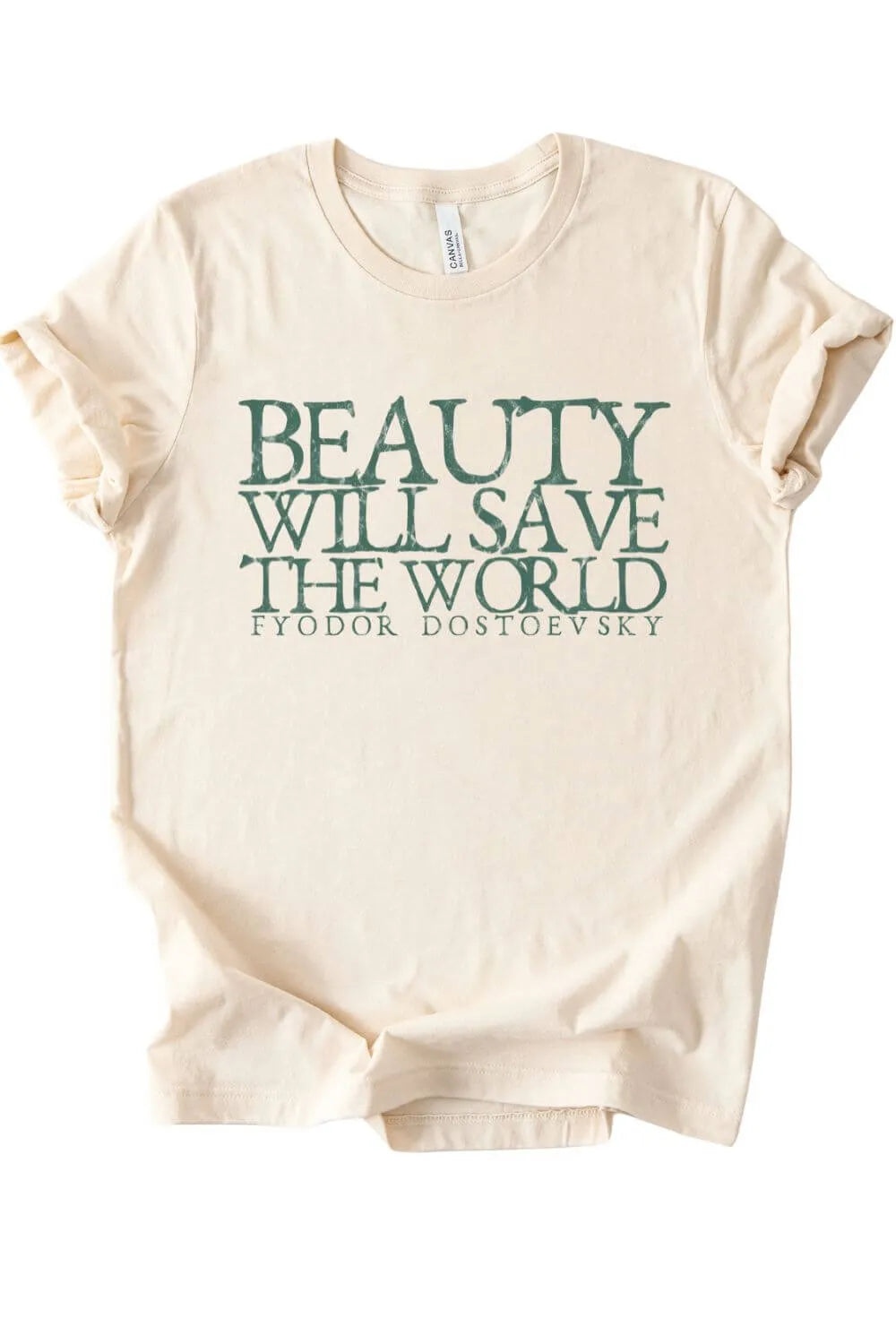 Cream colored t-shirt featuring the quote “Beauty Will Save The World” by Fyodor Dostoevsky in distressed green typography, styled flat lay as a dark academia literary shirt