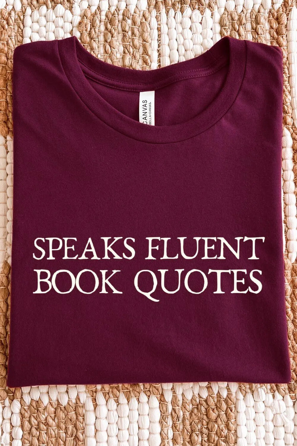 soft cotton maroon red  t-shirt with 'Speaks Fluent Book Quotes' text, folded on textile surface