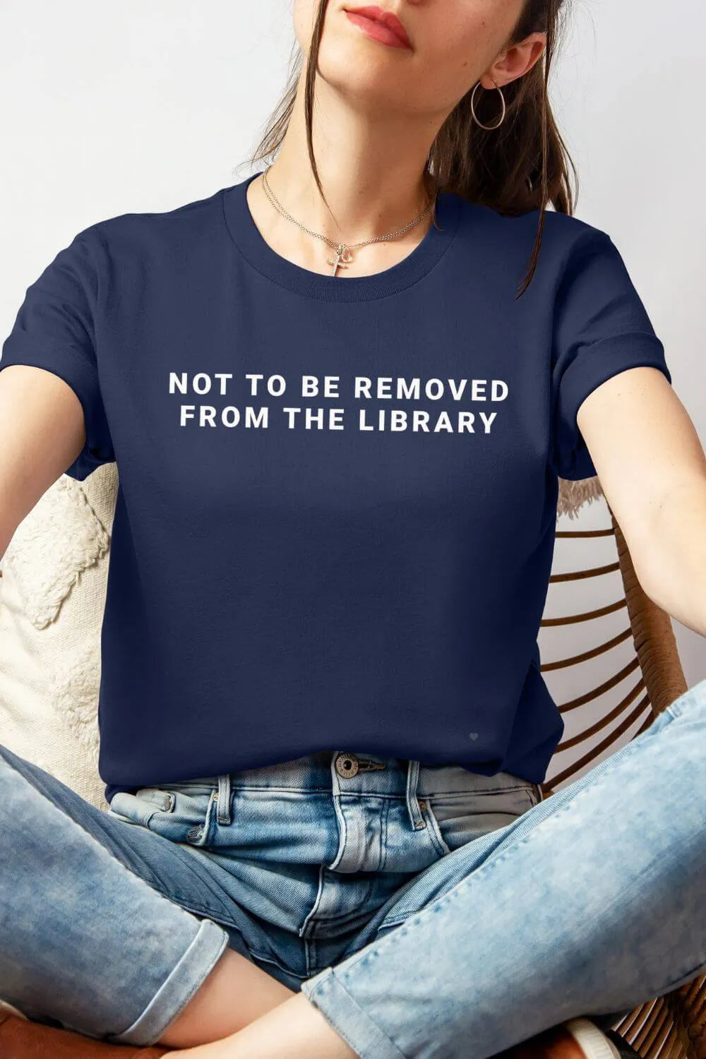 Navy bookish graphic t-shirt wearing by model, with “Not to Be Removed from the Library” text, styled outfit with jeans, casual introvert aesthetic