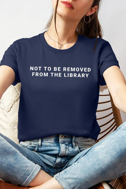 Navy bookish graphic t-shirt wearing by model, with “Not to Be Removed from the Library” text, styled outfit with jeans, casual introvert aesthetic