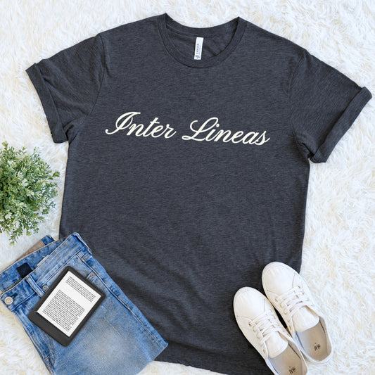Dark gray heather reader t-shirt with 'Inter Lineas' — Latin for between the lines text, paired with jeans and sneakers on a light background.