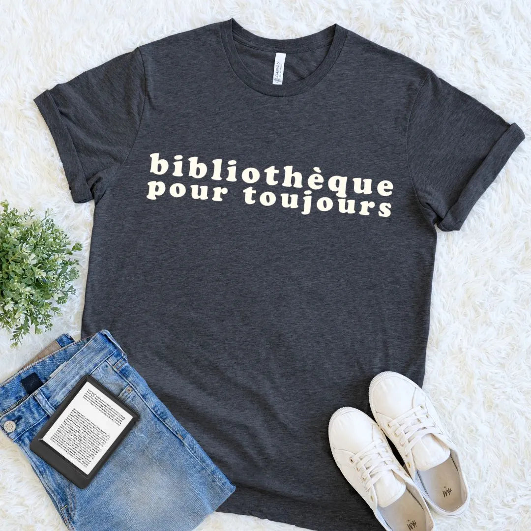 Dark grey heather bookish tee with bold Bibliothèque Pour Toujours typography, styled for a quiet day of reading