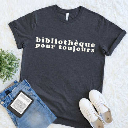 Dark grey heather bookish tee with bold Bibliothèque Pour Toujours typography, styled for a quiet day of reading