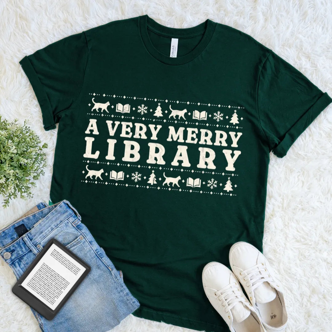 Forest green A Very Merry Library T-shirt with festive books, cats, snowflakes, and Christmas trees