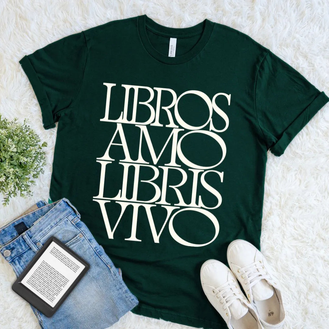 Forest green Latin quote shirt for devoted readers, featuring bold cream Libros Amo Libris Vivo lettering in a relaxed flat lay