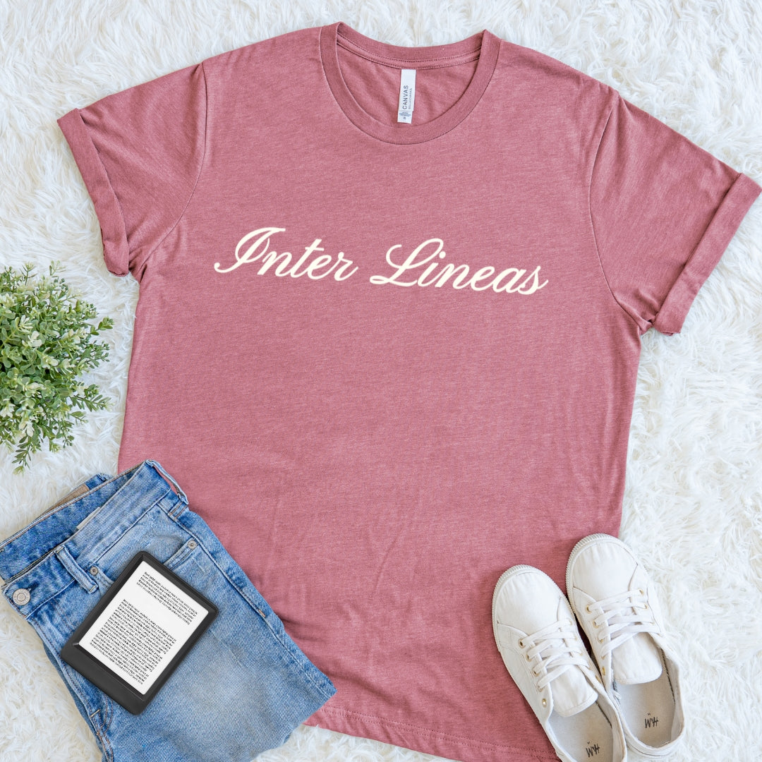 A heathered dusty rose t-shirt with the text   Inter Lineas lettering and a refined literary aesthetic for devoted readers, printed in cream across the chest.