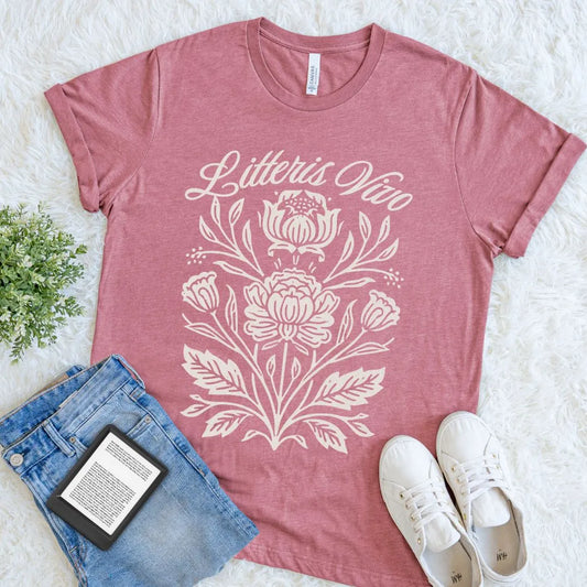 Heather mauve literary floral tee featuring Litteris Vivo in elegant script, arranged as a soft bookish flat lay