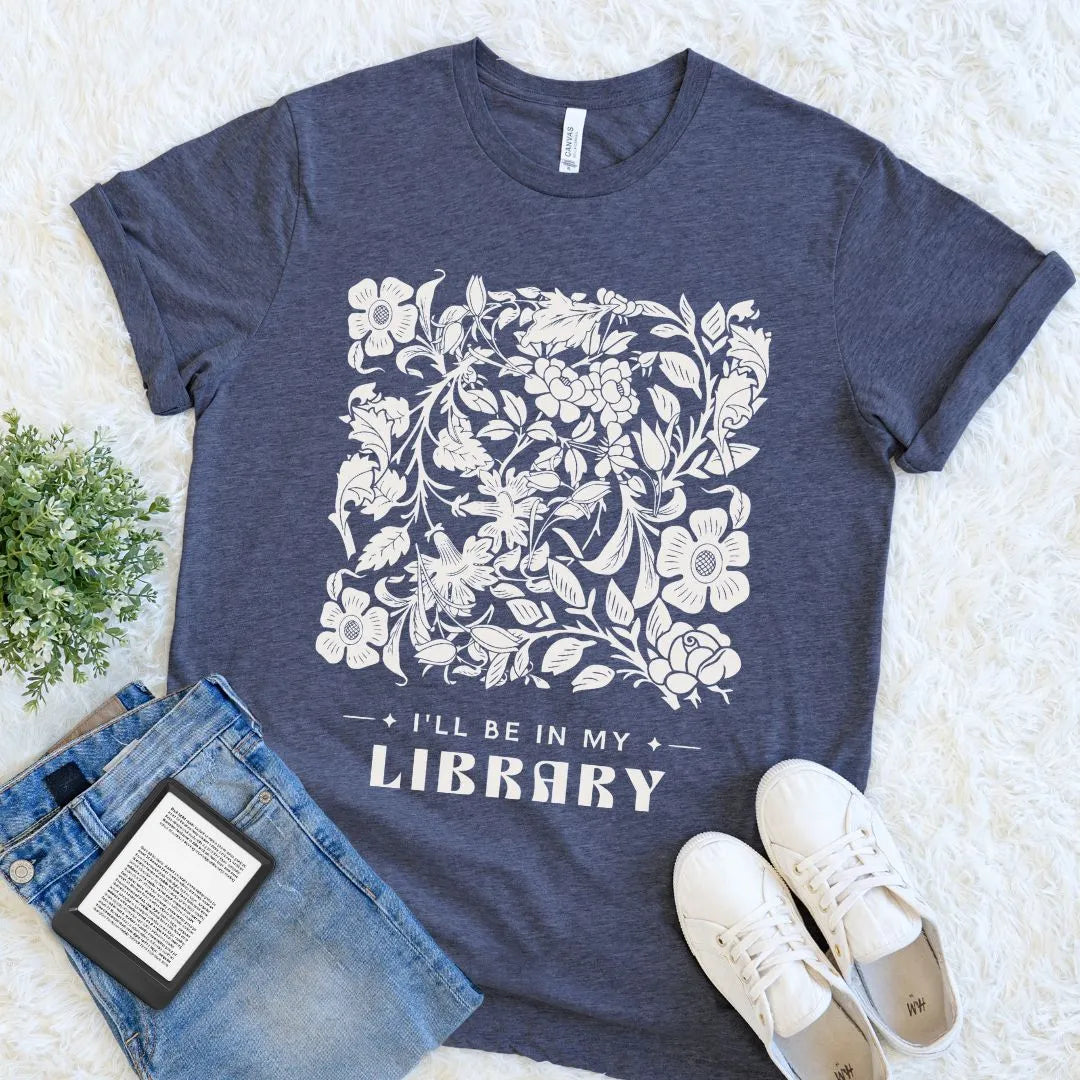  heather navy reader shirt with floral design and text 'I'll be in my library' on a light background