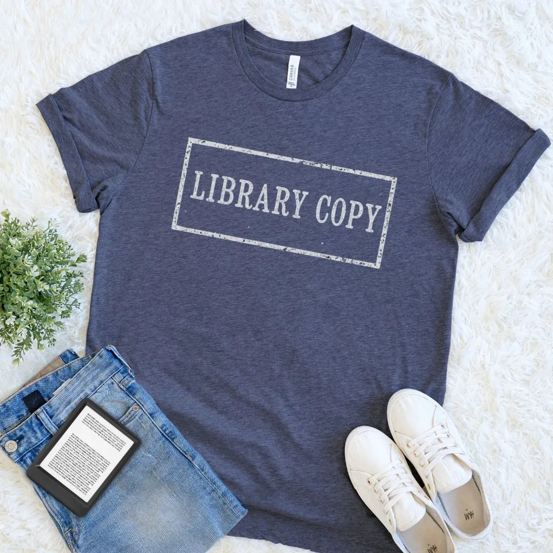 heather navy blue bookish  t-shirt with distressed Library Copy stamp typography in vintage style, paired with jeans and sneakers on a light background