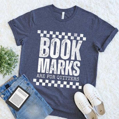Bookish aesthetic graphic tee in heather navy styled with ereader and denim outfit featuring "bookmarks are for quitters" typography