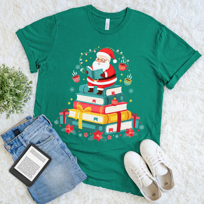 Santa reading on a giant stack of wrapped books with lights and cocoa on green t-shirt