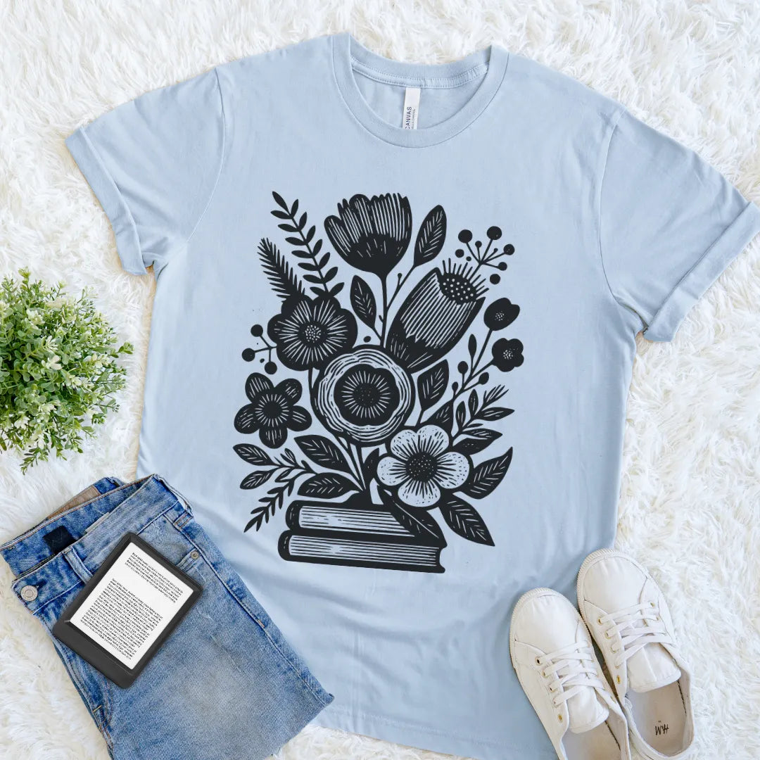 Vintage-style light blue reader shirt featuring black botanical flowers and stacked books design