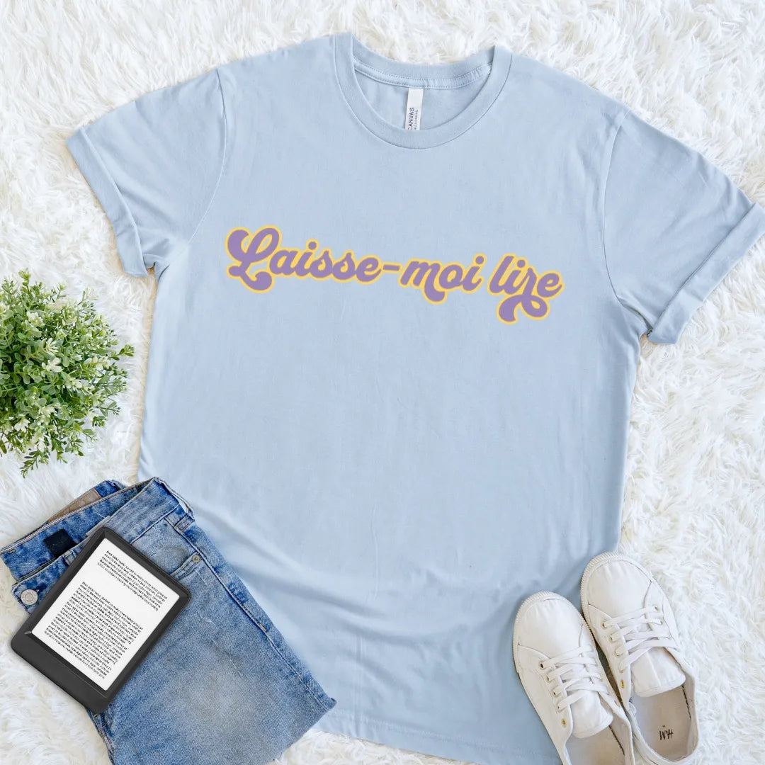 Light Blue Laisse-Moi Lire book lover T-shirt featuring colorful 1970s-inspired French typography, a cheerful retro reader tee meaning let me read.